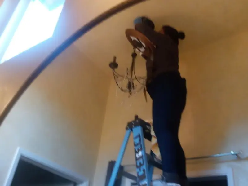 Electrician installing a chandelier in a Beavercreek residence
